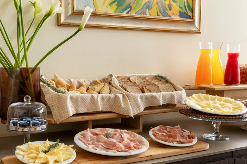 Buffet con pane assortito, formaggi, salumi e succhi freschi, ideale per una colazione completa in Liguria - Hotel Al Sant'Andrea, BZAR hotels in Liguria